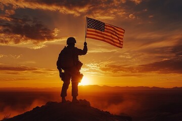 Silhouette of soldier holding united states flag on mountain top at sunset