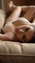 Obraz premium Woman in Lingerie Leaning on Plush Sofa