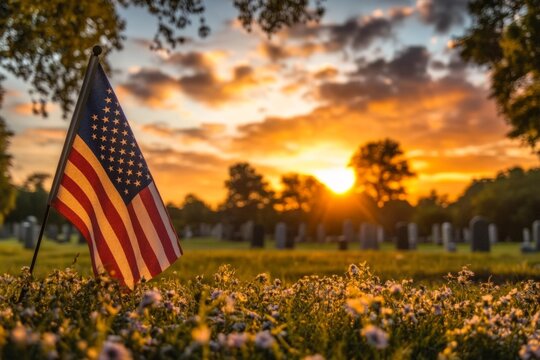 Small american flag waving in the wind during a beautiful sunset in a cemetery, honoring fallen heroes