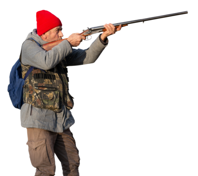 Mature hunter man holding a shotgun and walking through a field