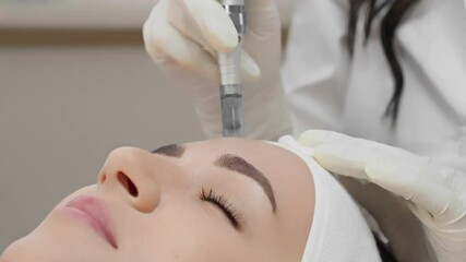 At a renowned skincare clinic, a skilled cosmetologist performs microneedling on a client, using innovative techniques to promote skin rejuvenation for a healthier, radiant complexion