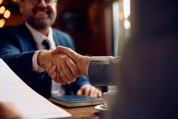 Close up of businessmen handshaking after successful deal.