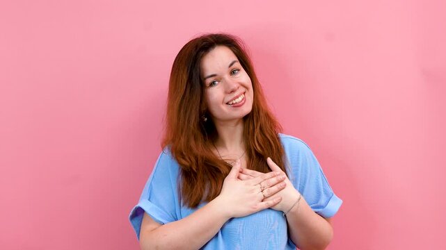 A young woman amiably shows you in my heart against an isolated background