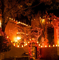 Fototapeta premium Farolitos and Christmas on Adobe Building in Old Town, Sante Fe, New Mexico, USA