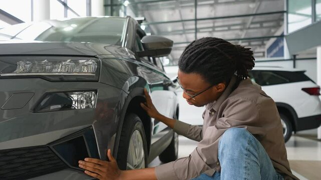 Man Inspecting New Car Exterior at Dealership Showroom