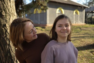 Obraz premium Mother and daughter share a joyful moment outdoors on a sunny day in a park
