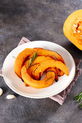 Vegetarian appetizer roasted pumpkin slices with spices and feta cheese on a gray background. Top view. 