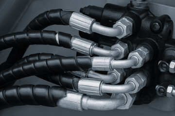 Bundle of pipes connected to industrial hydraulic pneumatic machine, industrial concept background