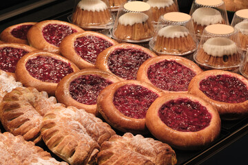 A display of pastries with a variety of flavors and textures. The pastries are arranged in a way that highlights their differences and invites the viewer to try them. Scene is one of indulgence