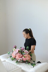 mulher florista arrumando arranjo de flores para casamento 