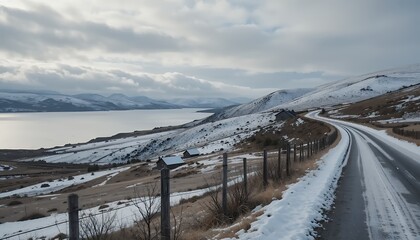 Obraz premium Driving Snowy Road Along Loch with Distant Mountain View