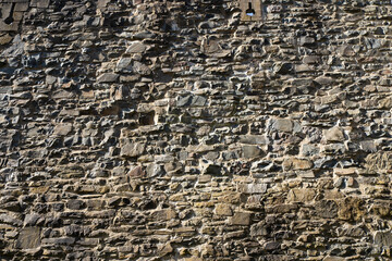 Stone wall made of antique old stone masonry close up. Wallpaper concept