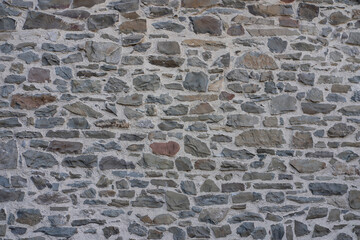 Stone wall made of antique old stone masonry close up. Wallpaper concept