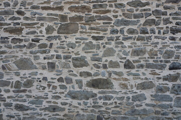 Stone wall made of antique old stone masonry close up. Wallpaper concept