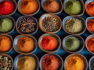 Assorted spice powders in ceramic bowls, displayed from a top view perspective to enhance any dish