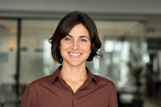 Happy young professional businesswoman manager, smiling confident female executive leader, woman entrepreneur or business owner looking at camera posing for headshot portrait in office at work.