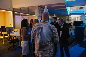 A White elder man is celebrating his retirement with a multinational group of his colleagues, all...