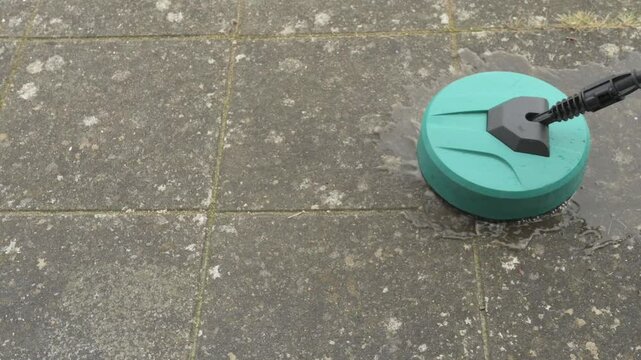 a round high-pressure washer cleaning old dirty concrete slabs