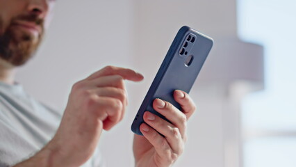 Guy finger tapping smartphone screen making online order morning room closeup