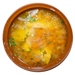 Deep clay bowl with Bulgarian fish and vegetable soup, complemented by cutlery and strong drink. Isolated over white background.