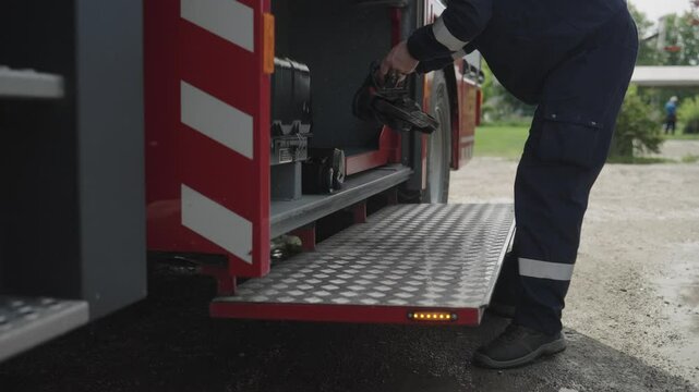 A professional firefighter meticulously prepares dangerous metal-cutting equipment on a firetruck, showcasing their readiness and expertise for high-stakes rescue operations in emergency situations