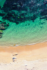 contrasting beach elements sand and rocky coastline. Aerial drone top down view. Background beach concept texture