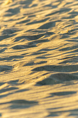 close-up of sand with contrasting light and shadows, detailed sand texture with warm lighting