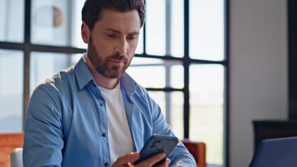 Fototapeta premium Shocked businessman receiving notification at laptop table workplace closeup