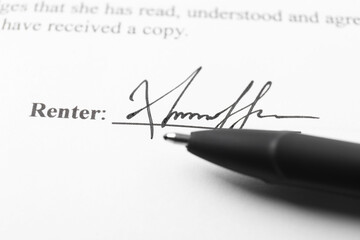 Signature and pen on paperwork, closeup view