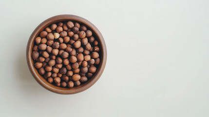 Fototapeta premium Minimalist food composition featuring a bowl of mixed nuts photographed from above, nuts gently overflowing onto a white background