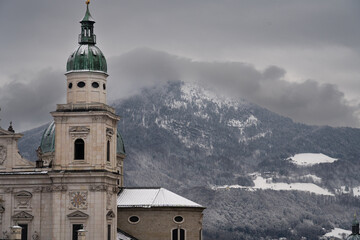 Cloudy Salzburg rooftop view, historical architecture, mountains, Austria winter.