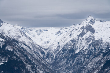 Cloudy January alpine landscape with mountains, trees, Austria.