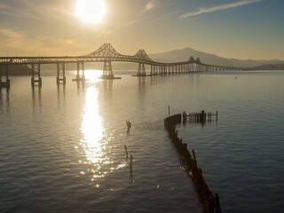 Obraz premium The Richmond-San Rafael Bridge spans the San Pablo Bay in Richmond, California, USA, The photo captures the bridge at sunset, with sunlight reflecting on the water.