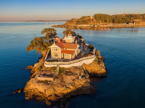An aerial view of the Brothers Island Lighthouse, a historic landmark in Richmond, California, USA. The lighthouse stands on a rocky island, surrounded by the tranquil waters of San Pablo Bay.