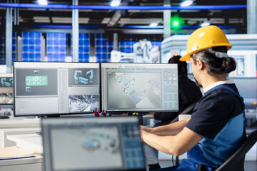 Photovoltaics factory specialist using PC to do performance testing of solar panel designs. Employee looking at computer monitor, improving existing solar panel configurations for cost reduction using