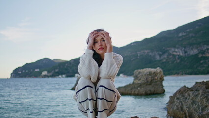 Fototapeta premium Calm tourist posing ocean coastal rocks at twilight closeup. Model relaxing