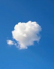 A fluffy white cumulus cloud floats serenely against a vibrant blue sky, purity, natural