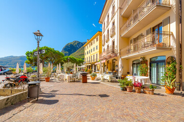 Fototapeta premium A lakefront sidewalk cafe on Piazza Garibaldi on a clear summer day in the picturesque Italian village of Menaggio, Italy, on the shores of Lake Como. 