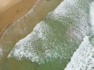 Solitary man walking on the sandy beach