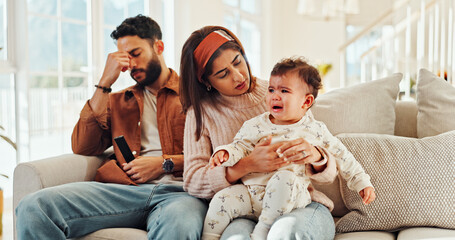 Family, man and woman with baby, crying and stress for new parents with child, lounge and home. Noise, father and annoyed by interruption from game, thinking or mother with emotional toddler in house