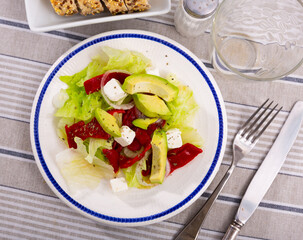 Appetizing salad of fresh vegetables with pim cheese, avocado and onion served on platter