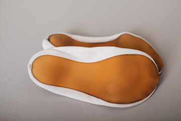 A close-up of the soles of white ballet or gymnastic slippers, showing their soft and flexible design.