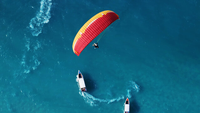 Paragliding in Thailand with blue sea. Two man paragliding high up in the sky. tourist attraction. Paraglider flies above the mountains in a bright sunny day.