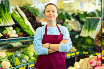 friendly woman seller of vegetable department is waiting for buyers