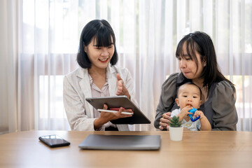 A woman is holding a tablet and pointing to something on it