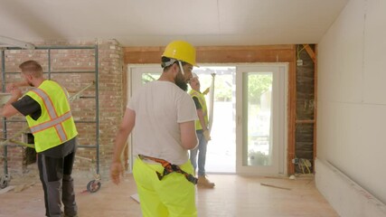 Diverse and talented group of builders is energetically working together at a construction site, focused on renovating and improving a new house with their specialized tools and detailed planning