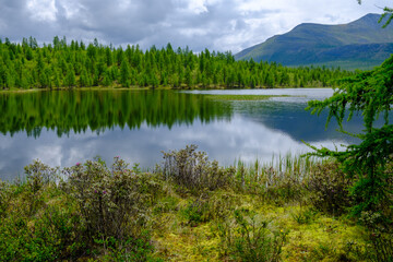 Sunset panorama of small lake with mountain reflection in Siberia, Buryatia, Russia
