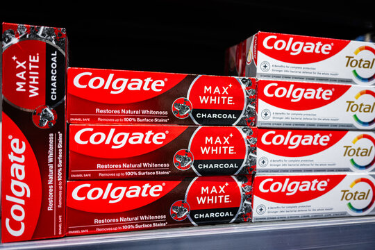 Colgate Max White Charcoal toothpaste packages displayed on a retail store shelf
