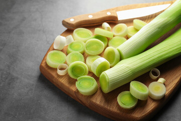 Chopped leeks and knife on grey table, closeup