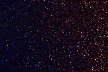 A dark blue and red background with a lot of glitter